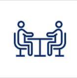 © Sylvia Garbislander Bild zeigt zwei stilisierte Menschen die sich an einem Tisch gegenübersitzen als Symbol für ein Bewerbungsgespräch