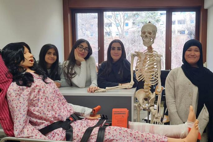 © Hanna Fisher Bild zeigt vier Schülerinnen der Pflegegruppe im Vordergrund ist die neue Pflegepuppe Sam und das Skelett Jack