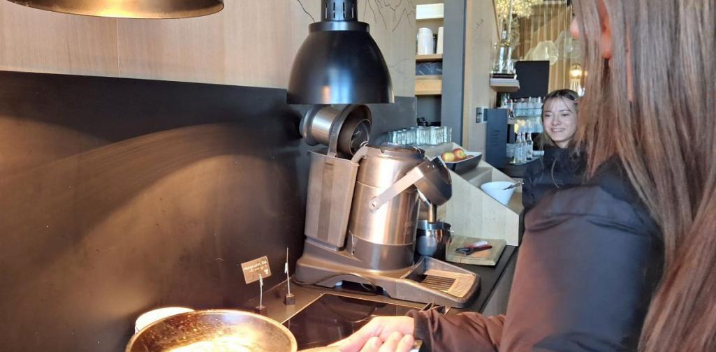 Bild zeigt eine Schülerin, die eine Pfanne mit einem Pancake hält